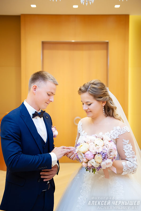 невеста одевает обручальное кольцо жениху — фото