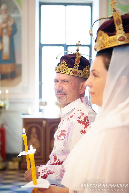 Венчальные короны на голове мужа и жены — фото